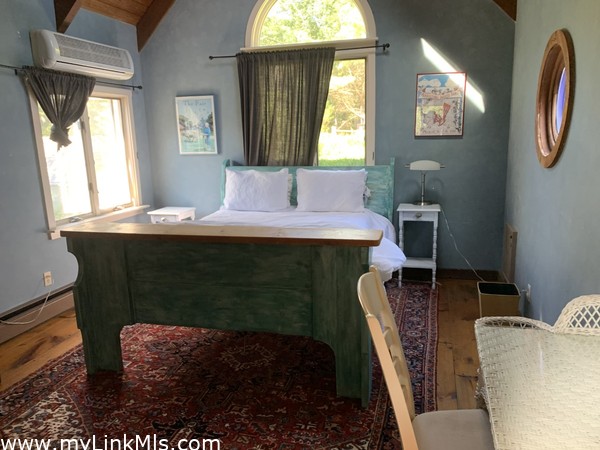 1st floor Queen Bedroom in a very large wide pine floor bedroom, cathedral with ceiling fan, round windows