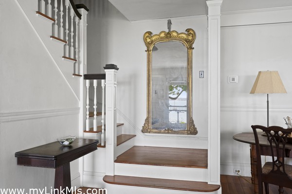 Front staircase with reflection of front entry in mirror