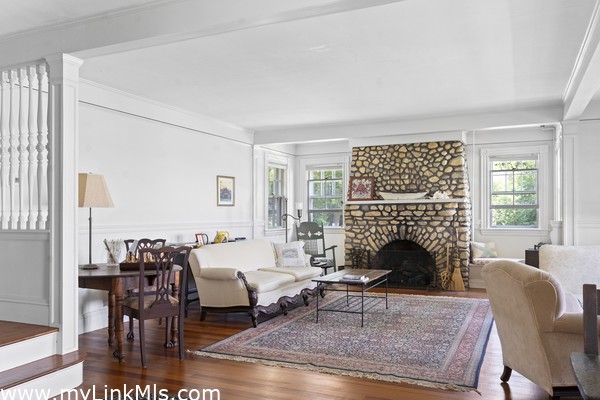 Living room with field stone fireplace and staircase at left