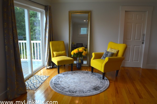 Sitting area leads to private balcony in primary bedroom