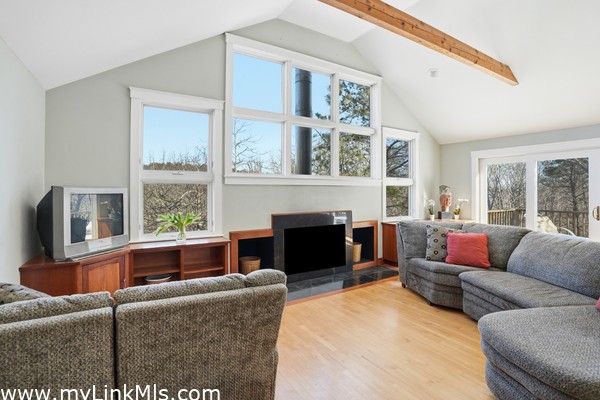 Amazing wall of windows letting in abundant light custom built-in cabinets and high vaulted ceiling