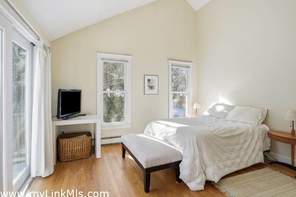 Primary bedroom with high vaulted ceiling.