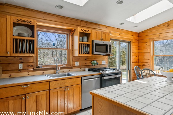 Guest house kitchen with casual dining area leading to large back deck, plus center island and seating