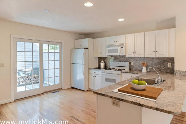 Sliders lead to side deck with outdoor shower and storage shed.