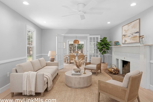 Large living room with Rumford fireplace with french doors that open to the dining room. Virtually staged.