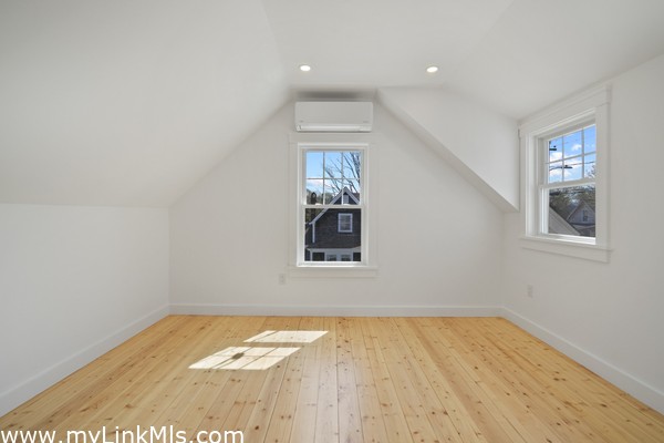 Main bedroom in primary unit with hardwood oak flooring and climate control.