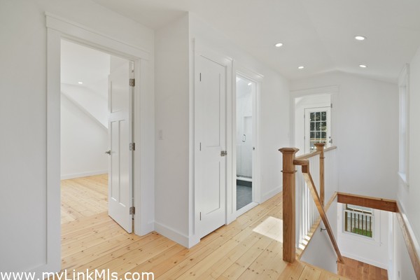 Second level landing and hallway to two bedrooms and full bathroom in primary unit.