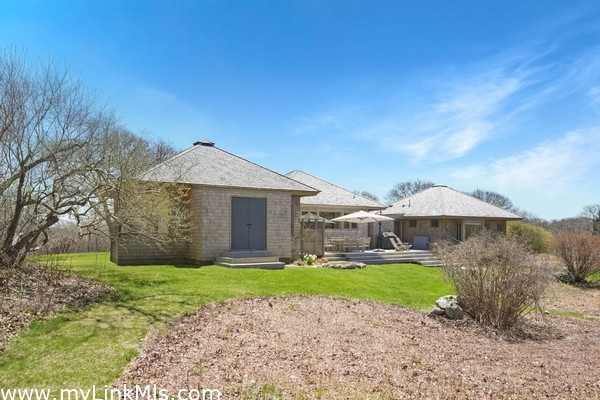 The back of the house has a large deck, storage and an outdoor shower.
