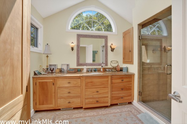 Spa-like primary bath with custom wood cabinetry and a double vanity