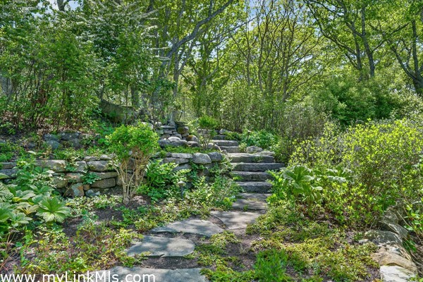 A beautifully landscaped, private woodland approach to the front door