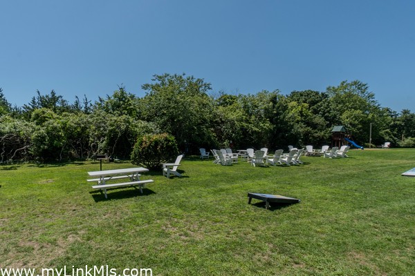 common area with picnic tables, corn hole games