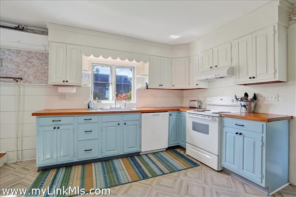 The country kitchen features new flooring and appliances.
